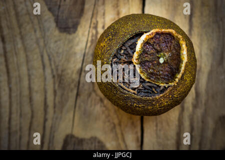 Fermentierte Alter schwarzen chinesischen Puer Tee in einer Mandarine trockene Schale mit Deckel, verwitterte Holz Hintergrund, Draufsicht, Exemplar Stockfoto