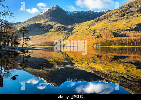Hohe Felsen spiegelt sich in Buttermere an einem ruhigen Wintermorgen in den Lake District National Park Stockfoto