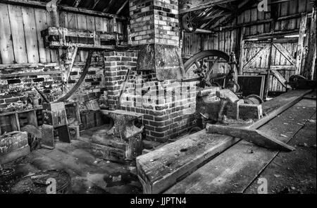 Innenbereich der Werkstatt ein Schmied mit verschiedenen Tools und Schmieden. Stockfoto