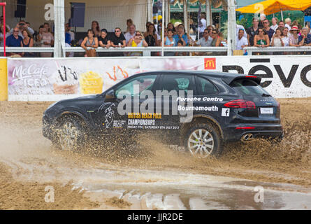 Charity-Rennen zwischen einem Porsche Wagen und Pferd findet statt am Strand bei den British Beach Polo Championships auf Sandbänken Strand, Poole Dorset im Juli Stockfoto