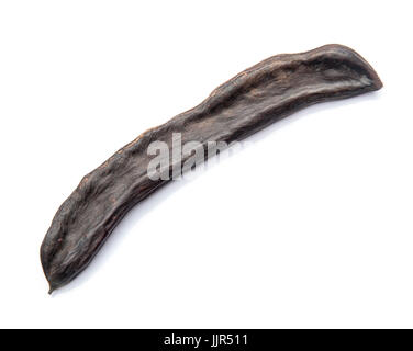 Eine schwarze Carob Schote auf weißem Hintergrund Stockfoto