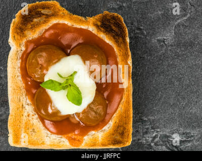 Fleischbällchen in Tomatensauce mit Mozzarella-Käse auf Toast vor schwarzem Schiefer Hintergrund Stockfoto