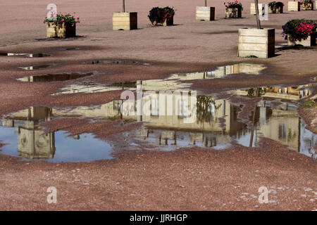 Gattschina-Palast spiegelt sich in einer Pfütze auf dem Exerzierplatz nach einem Regen. Stockfoto