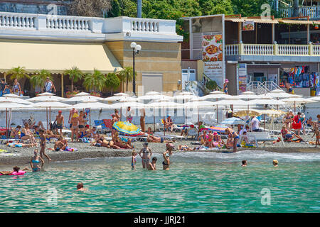 Sochi, Russland - 06. Juli 2017. die Leute Schwimmen und Sonnenbaden am Strand der Stadt Sotschi. Strand mit Touristen, Sonnenliegen und Sonnenschirmen Stockfoto