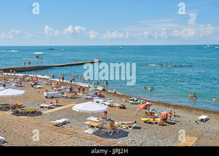 Sochi, Russland - 06. Juli 2017. die Leute Schwimmen und Sonnenbaden am Strand der Stadt Sotschi. Strand mit Touristen, Sonnenliegen und Sonnenschirmen Stockfoto