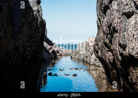 Der Natur Rahmen der Bass Rock, East Lothian, Schottland. Szene durch Lücke im Felsen des blauen Ozeans und fern Insel. Stockfoto