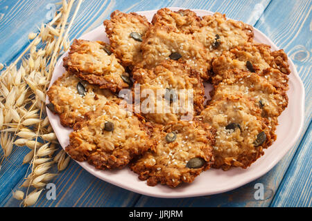 Frisch gebackene hausgemachte knusprige Haferkekse und Ohren des Hafers auf Brettern, Konzept der lecker gesundes dessert Stockfoto