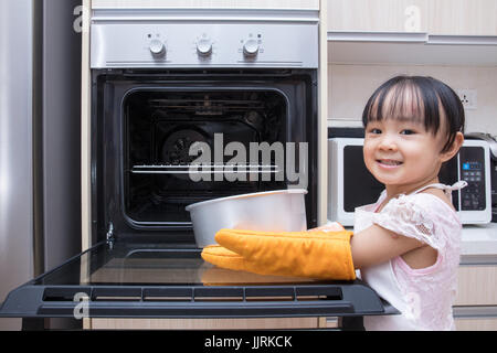 Asiatische chinesische Mädchen backen Kuchen zu Hause in der Küche Stockfoto