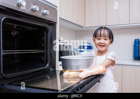 Asiatische chinesische Mädchen backen Kuchen zu Hause in der Küche Stockfoto