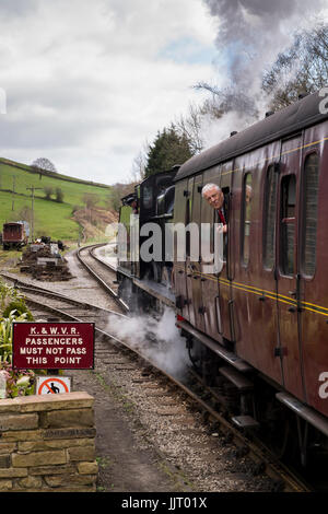 Dampf-Lokomotive BR (Midland Railway) 4F 0-6-0 43924 schnaufend Rauch, zieht in Station, Wache an Bord - Keighley & Wert Valley Railway, England, UK. Stockfoto