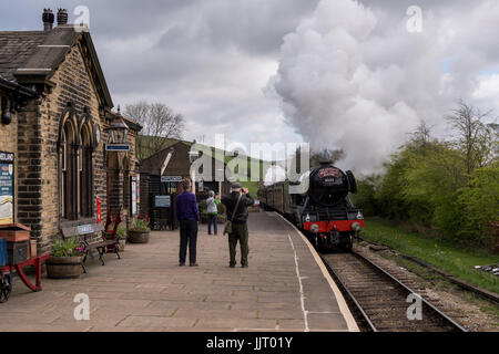 Menschen auf Zug Bahnhof Plattform Sicht legendären Dampflokomotive Motor 60103 Flying Scotsman, puffing Rauch - Keighley & Wert Valley Railway, GB, UK. Stockfoto