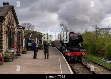 Leute auf Bahnsteig beobachten iconic Dampflok Motor 60103 Flying Scotsman, puffing Rauch - Keighley & Worth Valley Railway, GB, UK. Stockfoto