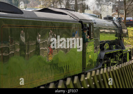 Fahrer in der Kabine & Fans in Grün glänzend Motor der legendären Dampflok 60103 Flying Scotsman - Keighley & Worth Valley Railway, England, UK wider. Stockfoto