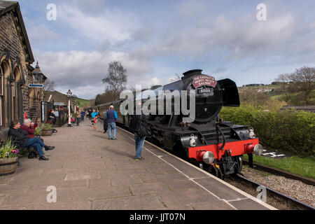 Menschen auf der Plattform anschauen & Wave an Treiber (iconic Dampflok Motor 60103 Flying Scotsman) an der Station - Keighley & Worth Valley Railway, GB, UK. Stockfoto