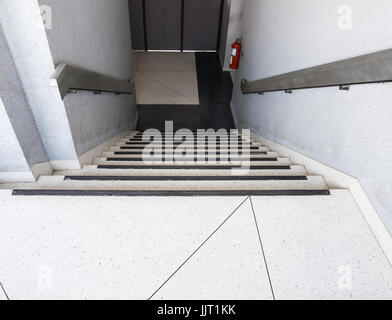 Ausfahrt Treppe nach unten auf dem Boden mit dem Feuerlöscher des Bürogebäudes im Stadtgebiet, Thailand ins Feuer. Stockfoto