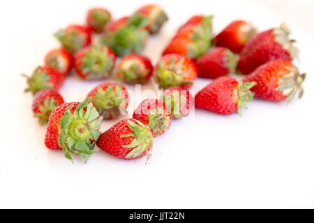 Erdbeeren, frische, lebendige rot in der Form eines Herzens Liebe vor einem weißen Hintergrund Stockfoto