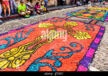 Antigua, Guatemala - März 24, 2016: die Einheimischen bewundern gefärbte Sägespäne Gründonnerstag Prozession Teppiche in der Stadt mit den berühmten Heiligen Woche feiern Stockfoto