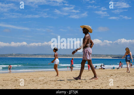 Schwarzer Mann kurz und mit Stroh Hut am Strand in St. Ives, Cornwall Stockfoto