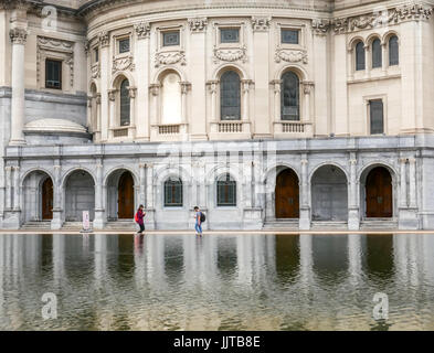 Zwei junge Leute mit Blick auf ihre Telefone beim Gehen vorbei an der reflektierenden Pool, Christian Science Center, Boston, Massachusetts, USA Stockfoto