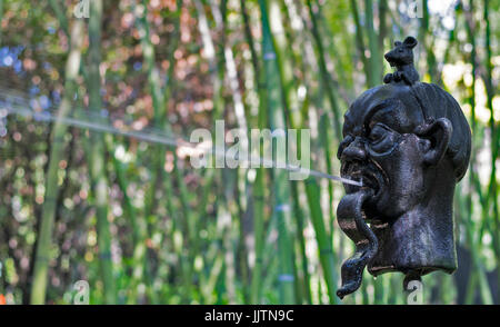 GARDASEE ITALIEN GARDONE DIE HELLER GARTEN SKULPTUR EINES KOPFES MIT EINEM WASSERSTRAHL AUS SEINEM MUND SPRITZEN Stockfoto