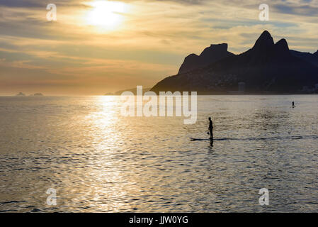 Stellen Sie Paddel bei Ipanema Sonnenuntergang mit zwei Brüder Hill und Gavea Stein im Hintergrund auf Rio De Janeiro Sommer Stockfoto