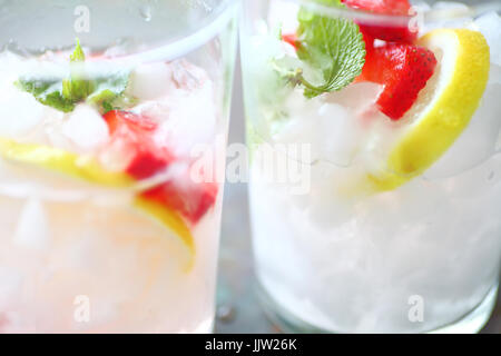 Nahaufnahme von zwei Gläser Obst - hineingegossenes Wasser mit frischen Erdbeeren, Zitronenscheiben und Minzeblättchen Stockfoto