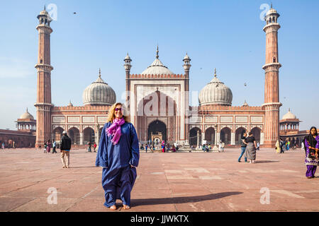 Eine weibliche Touristen posieren für Bild in Jama Masjid Moschee in Delhi, Indien. Frauen tragen passende Kleidung für eine Moschee oder Verschleiß das Gewand zu bieten Stockfoto