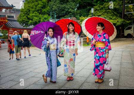 KYOTO, JAPAN - 5. Juli 2017: Junge Japanerinnen traditionellen Kimono trägt und hält Schirme in ihren Händen in der Gion Bezirk von Kyoto, Gion Stockfoto