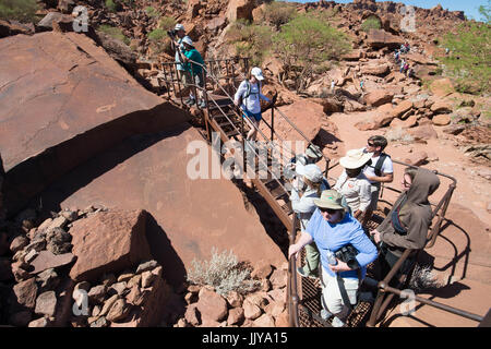 Touristen in Twyfelfontein, ein Ort der alten Steinmetzarbeiten von Damaraland Stämmen, befindet sich in Namibia, Afrika. Stockfoto