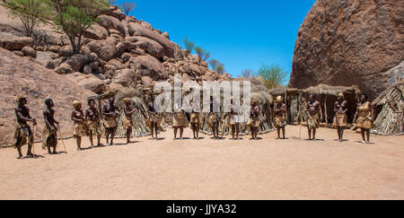 Damaran Völker stehen und singen in einer Linie mit der Damara Living Museum, befindet sich in Twyfelfontein, in der Nähe von Namibia, Afrika. Stockfoto