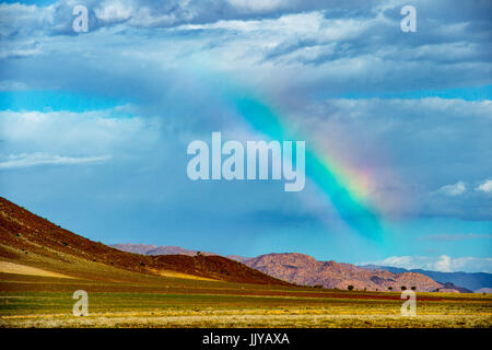 Ein Regenbogen wölbt sich über Berglandschaft in der Namib-Wüste, befindet sich in Namibia, Afrika. Stockfoto