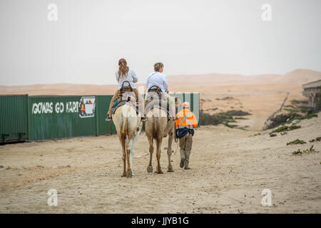 Touristen, Kamelreiten in der Namib-Wüste, Namibia, Afrika. Stockfoto