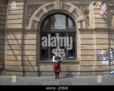 TGI Fridays Glasgow Buchanan Street Pfeifer in einem Kilt gerahmt im Fenster Stockfoto