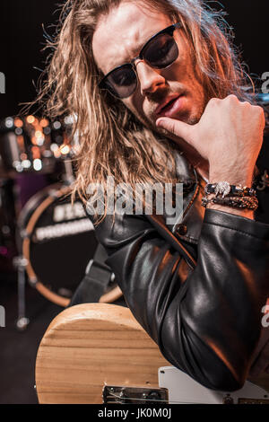 Gut aussehend Rockstar Brille posiert mit e-Gitarre auf der Bühne Stockfoto