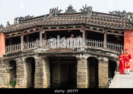 Ein paar Posen für Hochzeitsfotos vor die berühmte japanische Brücke in Hoi an eine möglichst bedeckt Touristen strömen in die Brücke Stockfoto