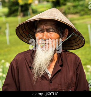 Vietnamesische Greis mit einem weißen Bart mit einem spielerischen Ausdruck Stockfoto