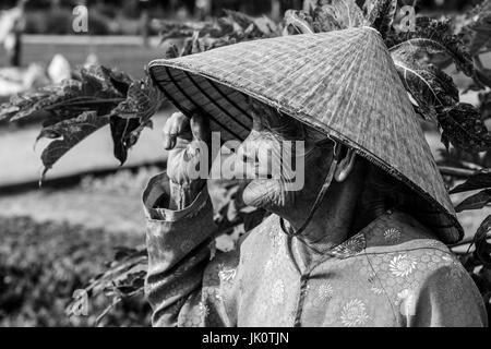 Alten vietnamesischen Dame in einem konischen Hut in Farbe - Tra Que - 13. März 2017 Stockfoto