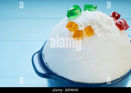 Closeup Aufnahme der große Kugel hausgemachte Gelato Eis in Keramikschale. mit kleinen lebendigen bunten Früchte Beeren Gelee und Kokosnuss Flocken an der Spitze Stockfoto