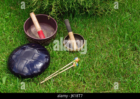 Klangschalen und Stahl Zunge Trommel auf dem Rasen Stockfoto