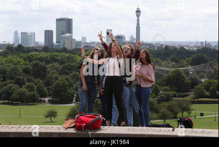 Primrose Hill Besucher nehmen eine "Selfie" vor dem Hintergrund der Londoner City in der Ferne hinter ihnen. Stockfoto