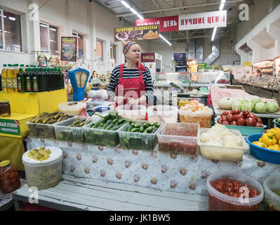 Frau, die hausgemachte Gurken auf dem kasanischen Markt in Tatarstan, Russland, verkauft Stockfoto