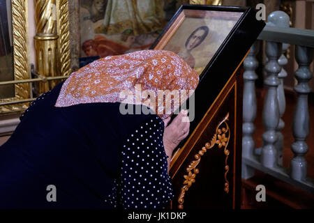 Eine ältere Russin betet vor einem religiösen Symbol in der orthodoxen Uspenskiy Sobor Kirche in der Stadt Biysk in Altai Krai, einer Region in Westsibirien, Russland Stockfoto