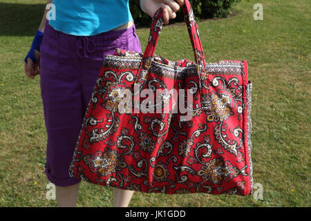 Strandtasche, die in einer Strandmatte erweitert Stockfoto