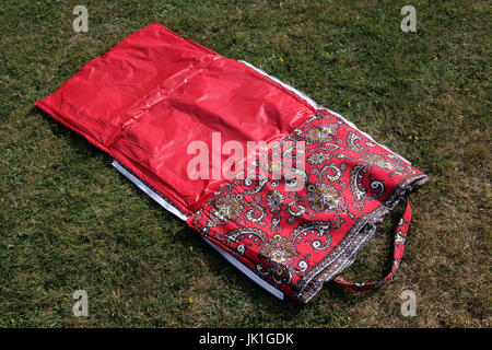 Strandtasche, die in einer Strandmatte erweitert Stockfoto