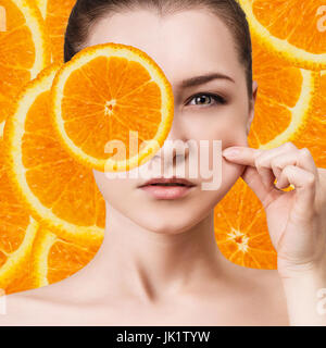 Junge Frau über orange Frucht Scheiben Hintergrund. Stockfoto