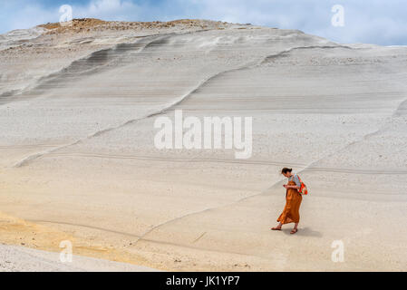 Milos, Griechenland, 17. Mai 2017: Junge Frau auf einem vulkanischen Felsen am schönen Strand von Sarakiniko. Insel Milos, Griechenland. Stockfoto