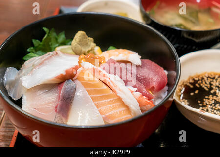 Japanisches Essen mit rohen Fischen, genannt Sashimi auf den Reis in die Schüssel in Hakodate Morgen Markt, Hokkaido, Japan. Stockfoto