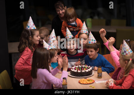 Der junge freudig feiert seinen Geburtstag mit einer Gruppe seiner Freunde Stockfoto