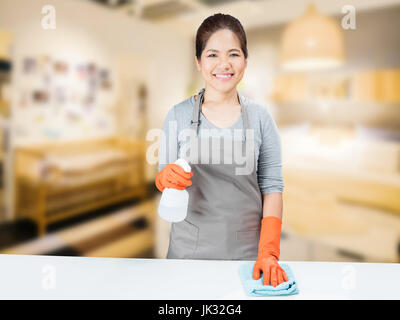 asiatische Hausfrau am Tisch fegen Stockfoto