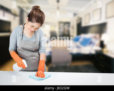 asiatische Hausfrau am Tisch fegen Stockfoto